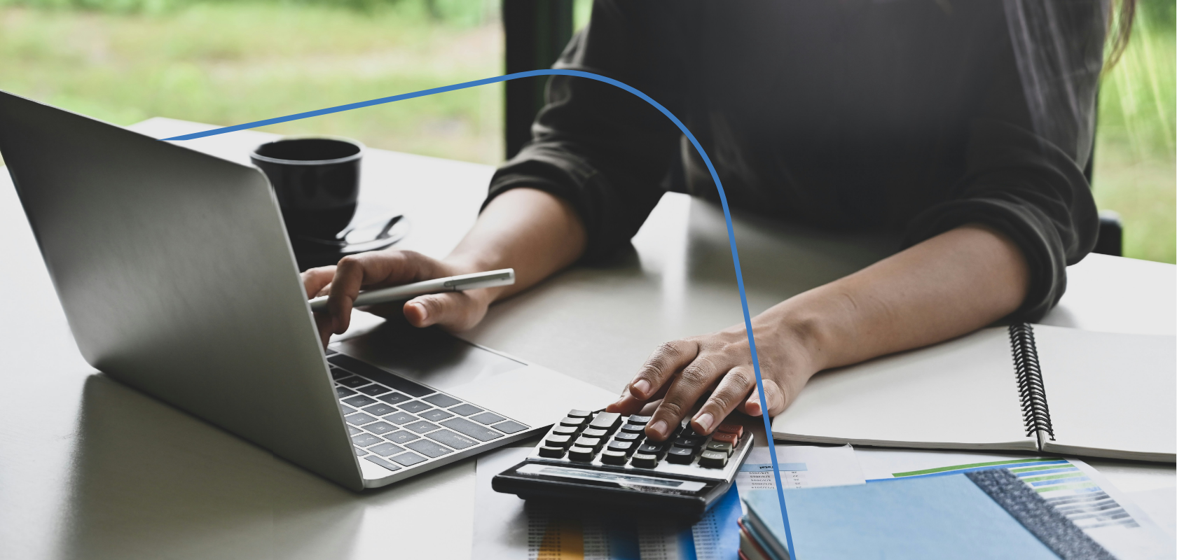 Bookkeeper at a laptop with a calculator, processing payroll
